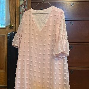 A cute Light pink dress decorated with Pom poms, flowy and low V-neck
